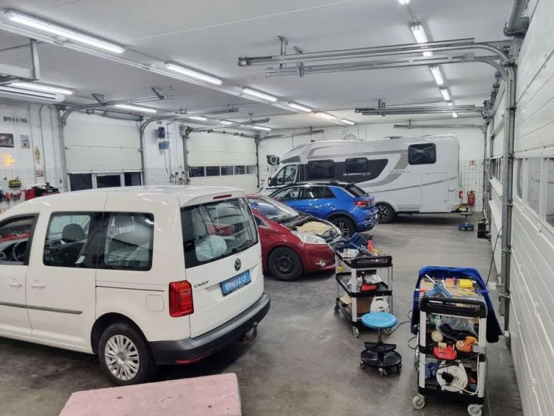 Werkstatthalle mit Fahrzeugen und Werkzeugwagen