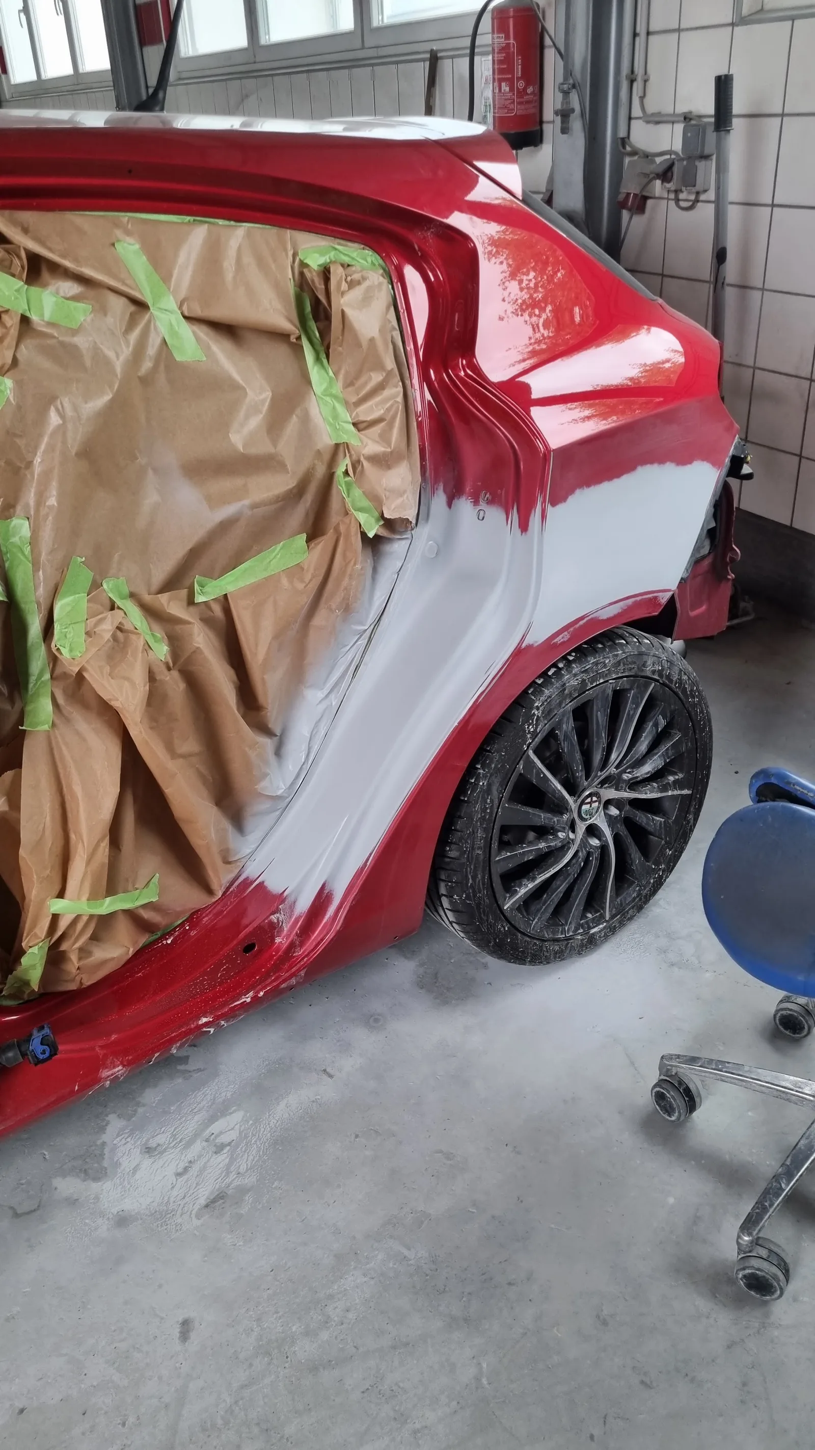 Rotes Fahrzeug für Lackierarbeiten sorgfältig abgeklebt